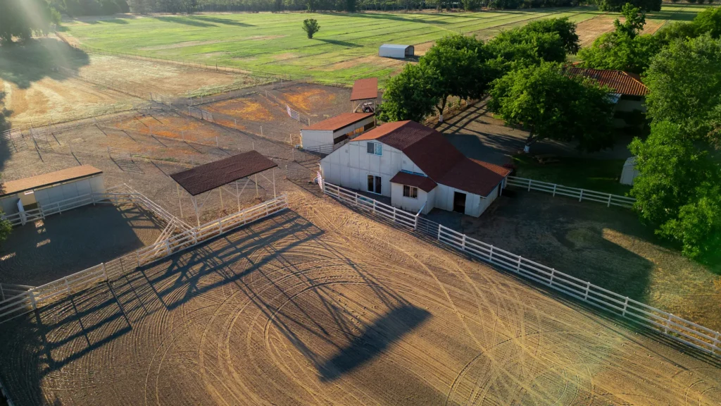 Drone view of barns, arena, round pen, and paddocks.