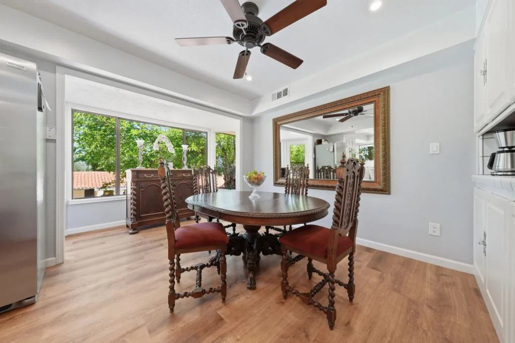 Sunlit dining nook overlooking mature landscaping.