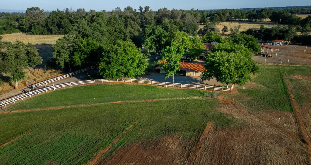 Aerial of the complete 23-acre Churn Creek Estate showing residence, barns, and pastures.
