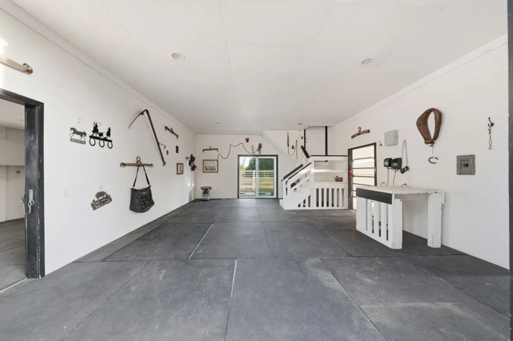 Interior aisle of the main horse barn with stalls on both sides.