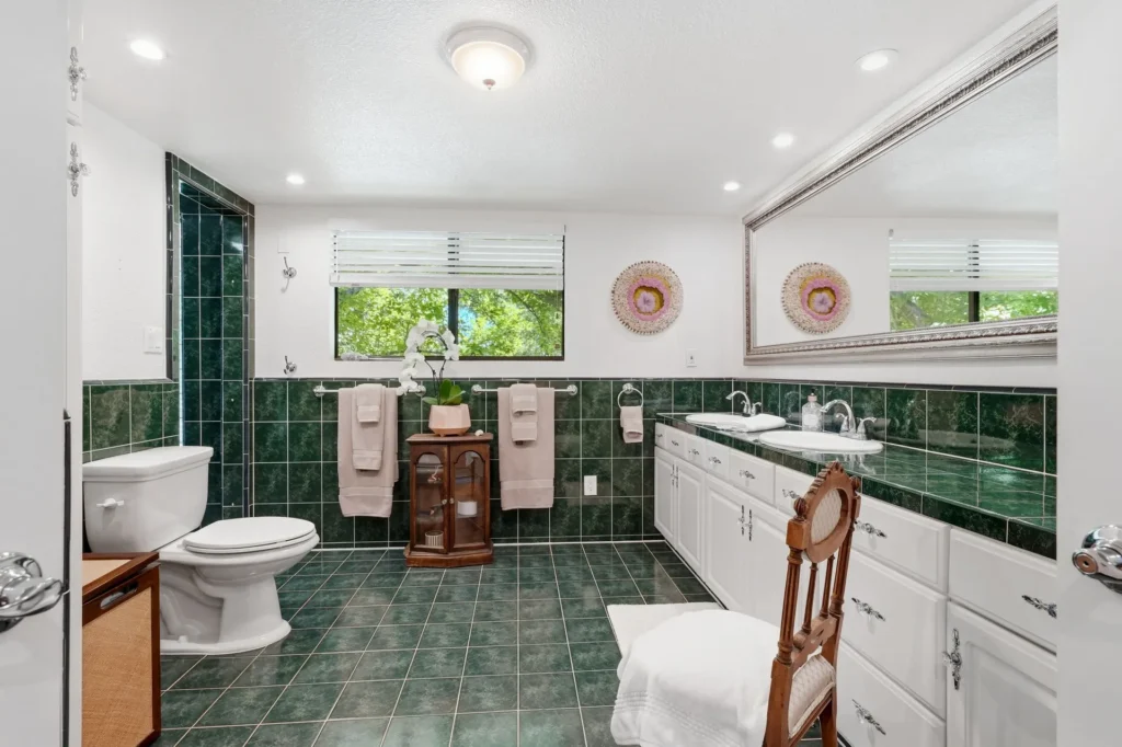 Primary bathroom with dual vanities and natural light.