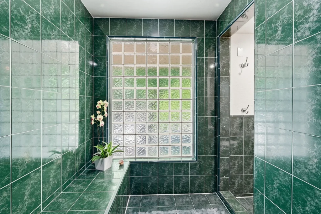 Glass-enclosed walk-in shower with tile surround in the primary ensuite.
